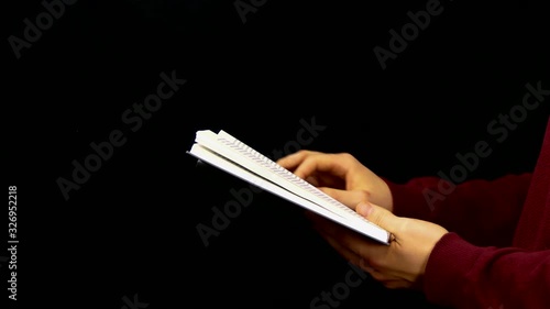 Male Hands Skip Pages Of a Book Over Black Background