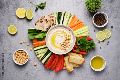 Fototapeta Hummus plate with a variety of vegetables and bread