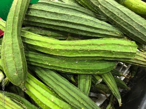 Pile of loofash squash for sale at the fresh produce section of a grocery.