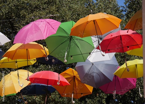 Close up of colorful umbrellas hanging from wires