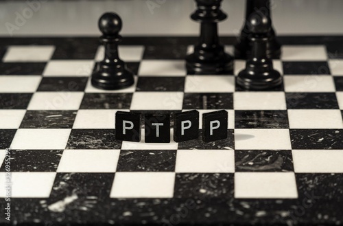 ptpp the word or concept represented by black and white letter tiles on a marble chessboard with chess pieces