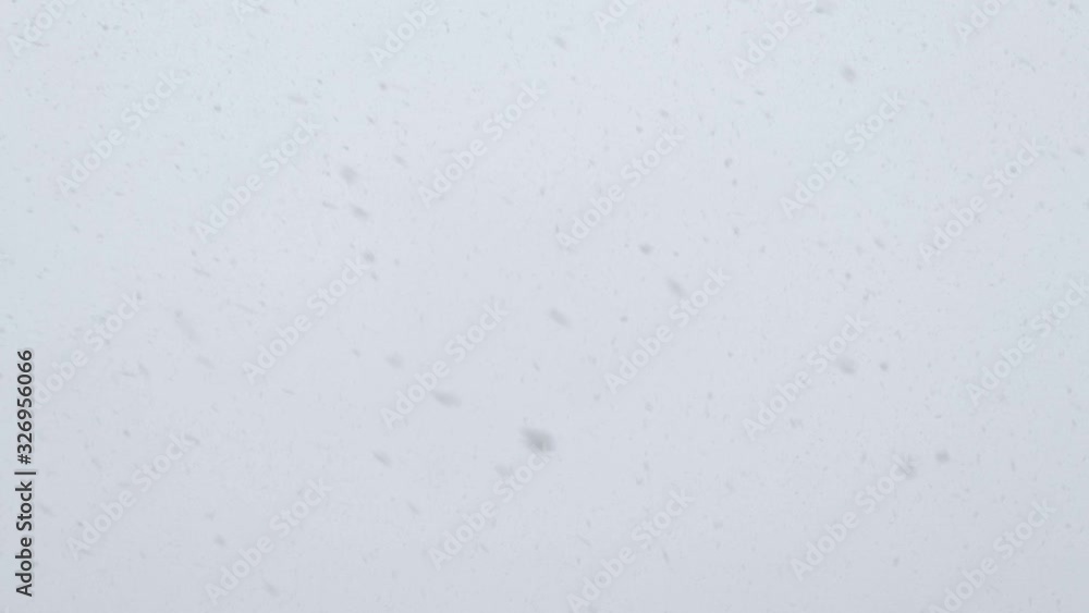 A heavy snowfall outdoors on natural sky background A heavy snowfall outdoors on natural sky background
