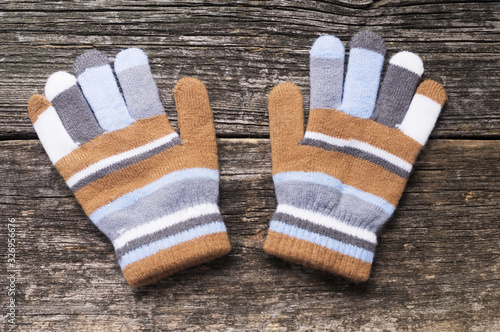 Multi-colored gloves on wood background