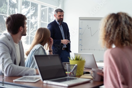 Business man making a presentation at office. Business executive delivering a presentation to his colleagues during meeting or in-house workshop