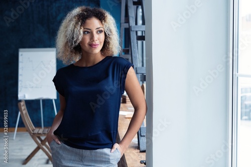Modern young African business woman in the office with copy space.