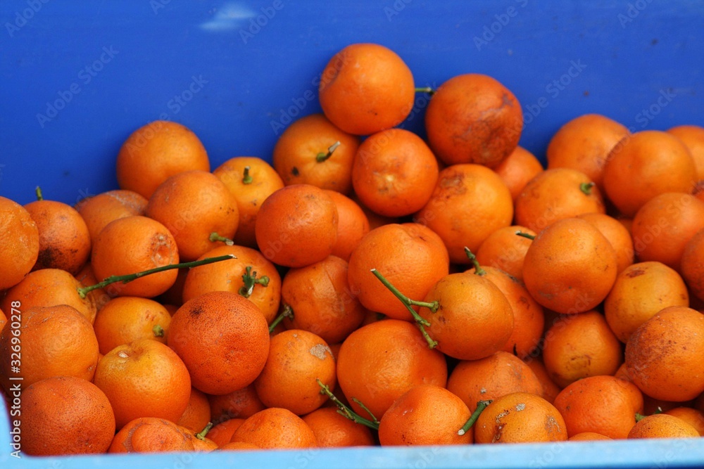 Pile of ripe mandarin fruits in a fruit stall