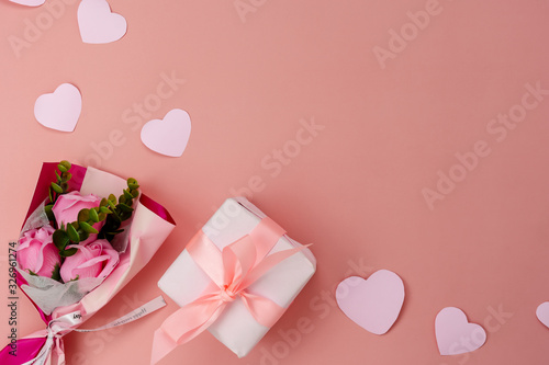 Table top view aerial image of decorations for international women's day holiday concept background.Flat lay sign of season the word 8 march happy woman's day with flower and gift box on pink paper.
