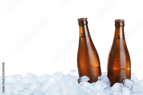 Ice cubes and bottles of beer on white background