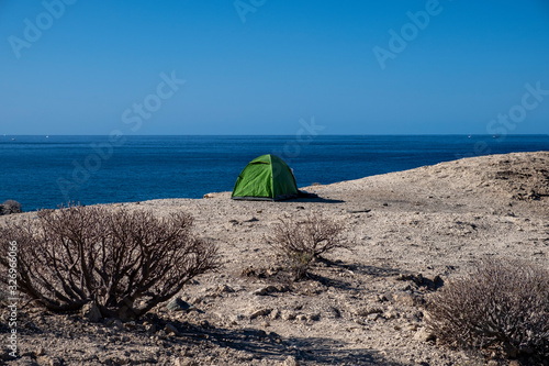 Green tent pitched on the cliff on the coastline near Adeje  Ternerife  Spain