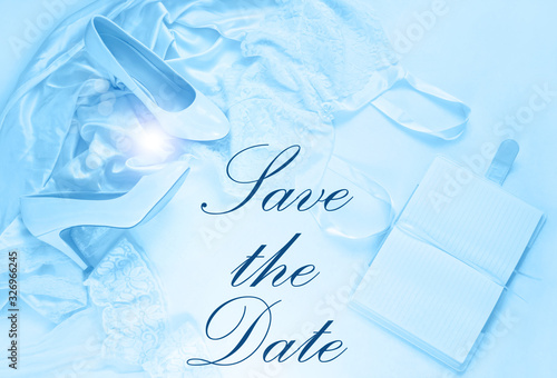 Fototapeta Naklejka Na Ścianę i Meble -  Wedding card Save the Date sign text, flat lay in classic blue color toning. Bridal details concept, silk lace dress,notebook mockup,fashion shoes top view. Female blog stylish accessories copy space.