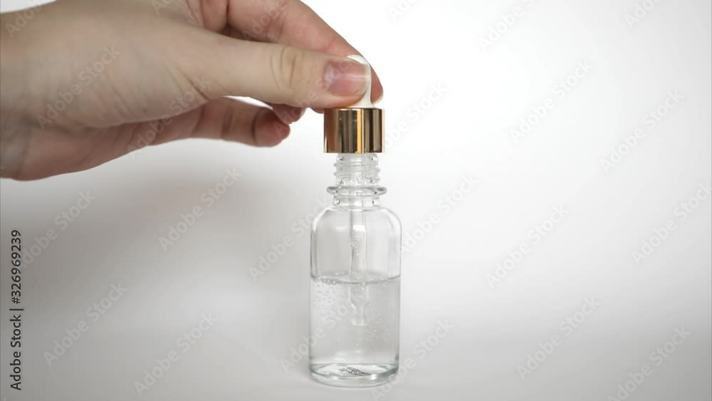 Hyaluronic acid drop falls from cosmetic pipette on white background, The Dropper glass Bottle Mock-Up Hyaluronic acid drop falls from cosmetic pipette on white background, The Dropper glass Bottle Mock-Up