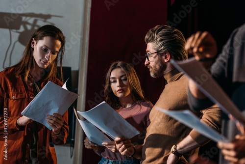 Foto Theater director, actor and actress rehearsing with scripts on stage
