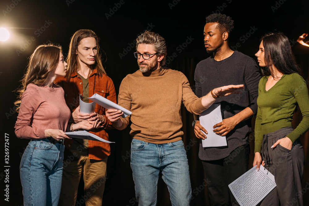 multiethnic actors and actresses rehearsing with theater director on stage - obrazy, fototapety, plakaty 