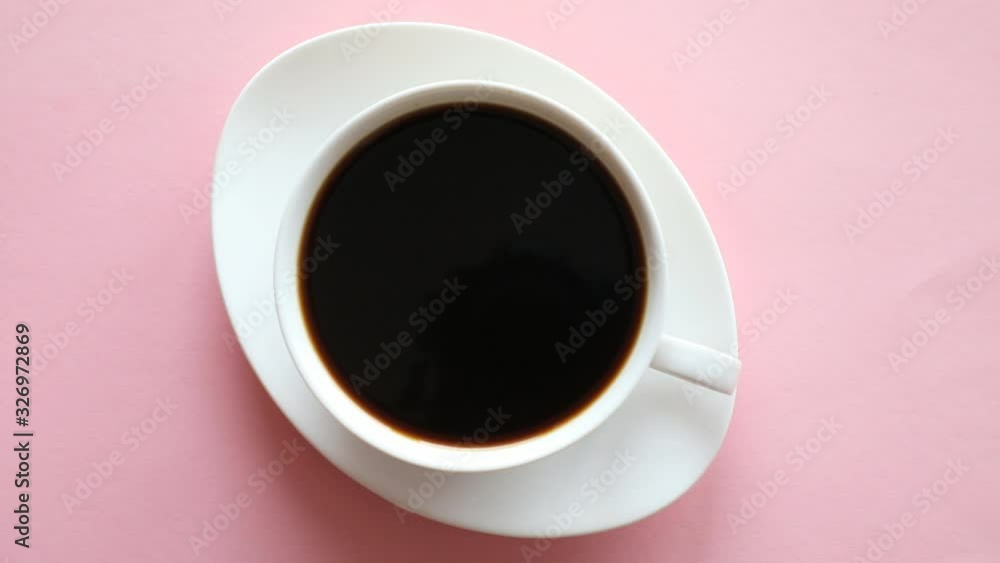One small cup of coffee on pink background with free space for text One small cup of coffee on pink background with free space for text