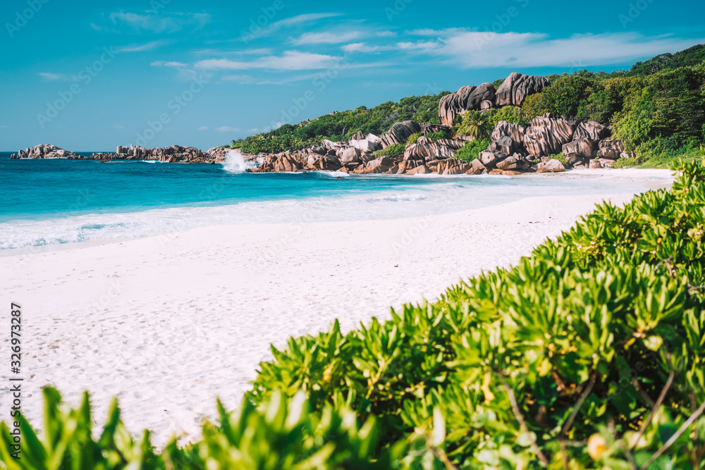 Vacation holiday wallpaper postcard background. Grand Anse tropical beach in La Digue, Seychelles. Famous granite rock formations Vacation holiday wallpaper postcard background. Grand Anse tropical beach in La Digue, Seychelles. Famous granite rock formations