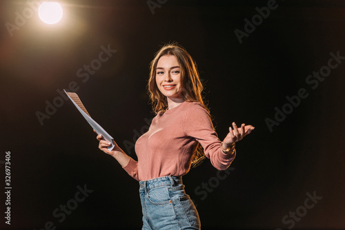 smiling young actress with screenplay on black photo