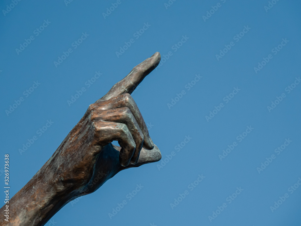 SAINT RAPHAEL, FRANCE - JANUARY 1, 2020: The pointing bronze hand. SAINT RAPHAEL, FRANCE - JANUARY 1, 2020: The pointing bronze hand.