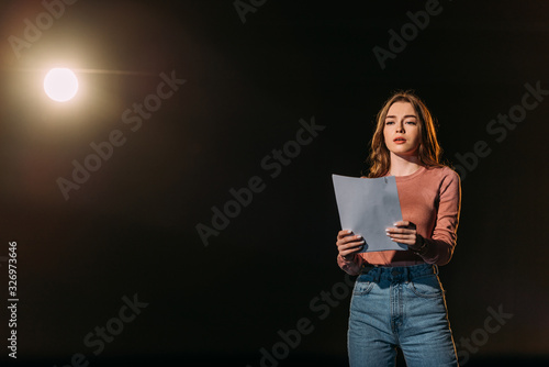 Tela beautiful young actress reading scenario on black