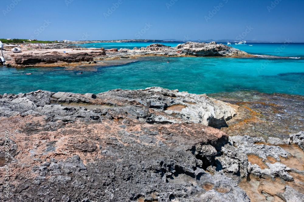 Panoramic view of the rocky coast and the transparent blue waters of Formentera in the Balearic Islands in Spain.