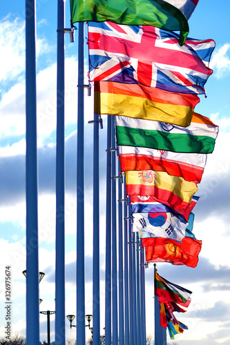 National flags of different countries in a row on flagpoles