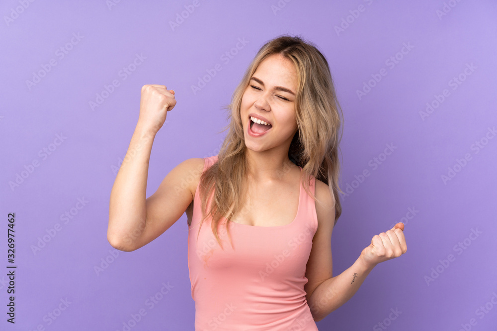 Fototapeta premium Teenager Russian girl isolated on purple background celebrating a victory