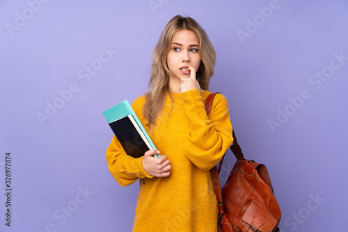 Teenager Russian student girl isolated on purple background nervous and scared