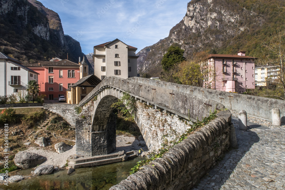 BIGNASCO, SWITZERLAND - OCTOBER 24, 2017: A picturesque village in a valley Maggia, canton Ticino. Special are the ancient stone bridge and the church from 15th century.