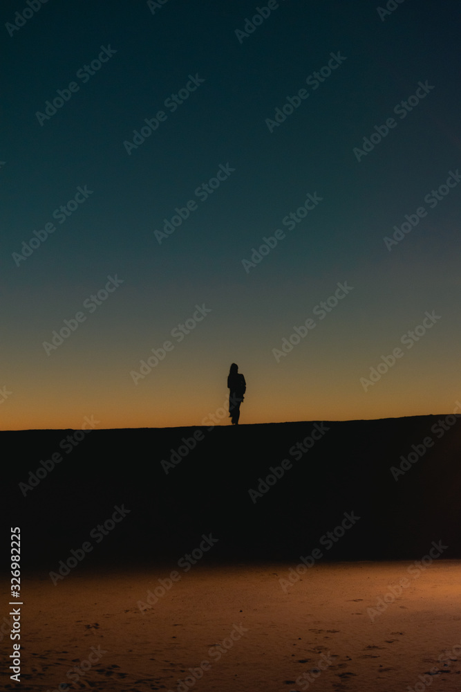 silhouette of woman on the desert at sunset
