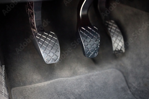 Element of modern luxury car interior metal gas clutch and brake pedal. Sport car with manual gearbox controls. photo