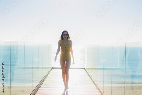 Portrait beautiful young asian woman walk with smile and look around beach sea ocean