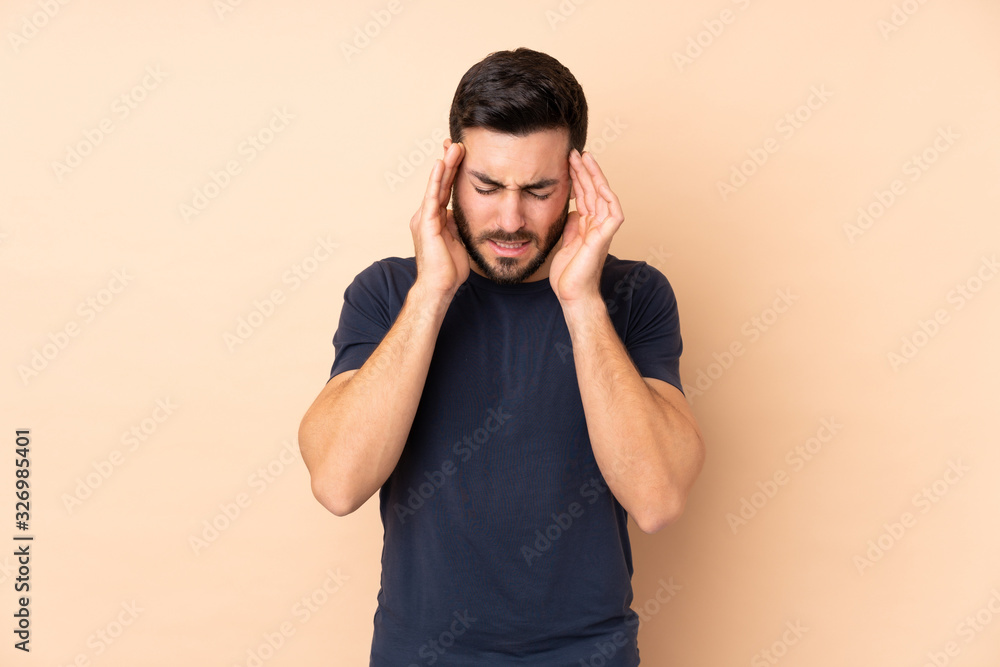 Caucasian handsome man isolated on beige background with headache Caucasian handsome man isolated on beige background with headache