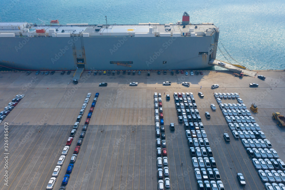 Obraz premium Cars export terminal in export and import business and logistics. Shipping cargo to harbor. Water transport International. Aerial view and top view.