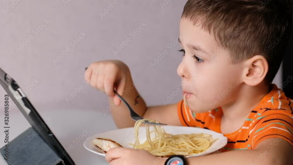 child playing with pasta at dining table. messy face eating. sauce and kid. boy eats pasta noodles sitting in nursery cafe. Happy child eating healthy organic and vegan food in restaurant. child playing with pasta at dining table. messy face eating. sauce and kid. boy eats pasta noodles sitting in nursery cafe. Happy child eating healthy organic and vegan food in restaurant.