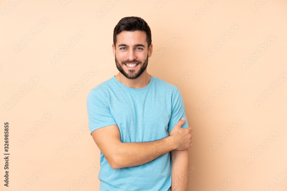 Caucasian handsome man isolated on beige background laughing Caucasian handsome man isolated on beige background laughing