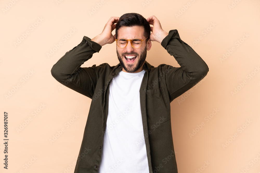 Caucasian handsome man isolated on beige background laughing Caucasian handsome man isolated on beige background laughing
