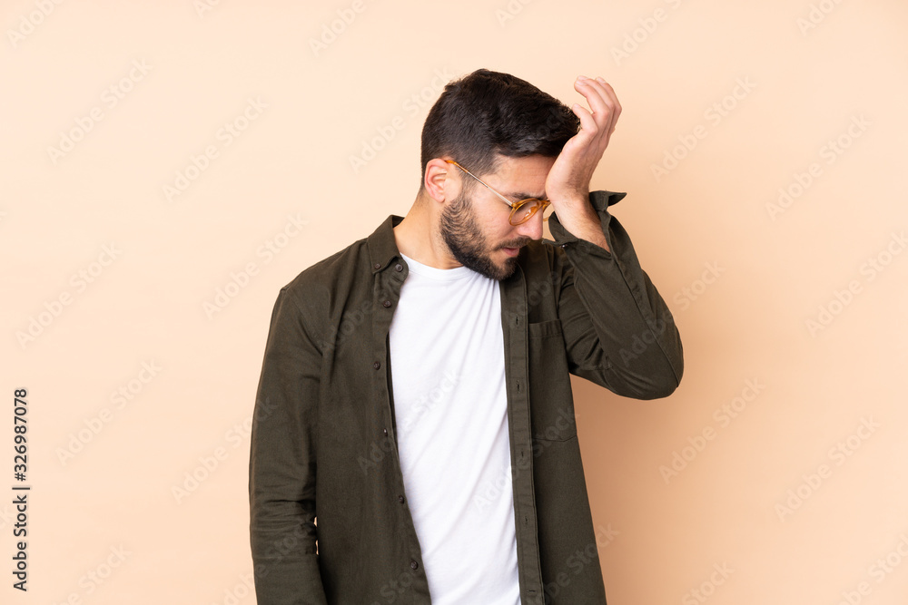 Caucasian handsome man isolated on beige background with headache Caucasian handsome man isolated on beige background with headache