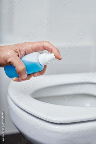 man disinfecting the toilet seat photo