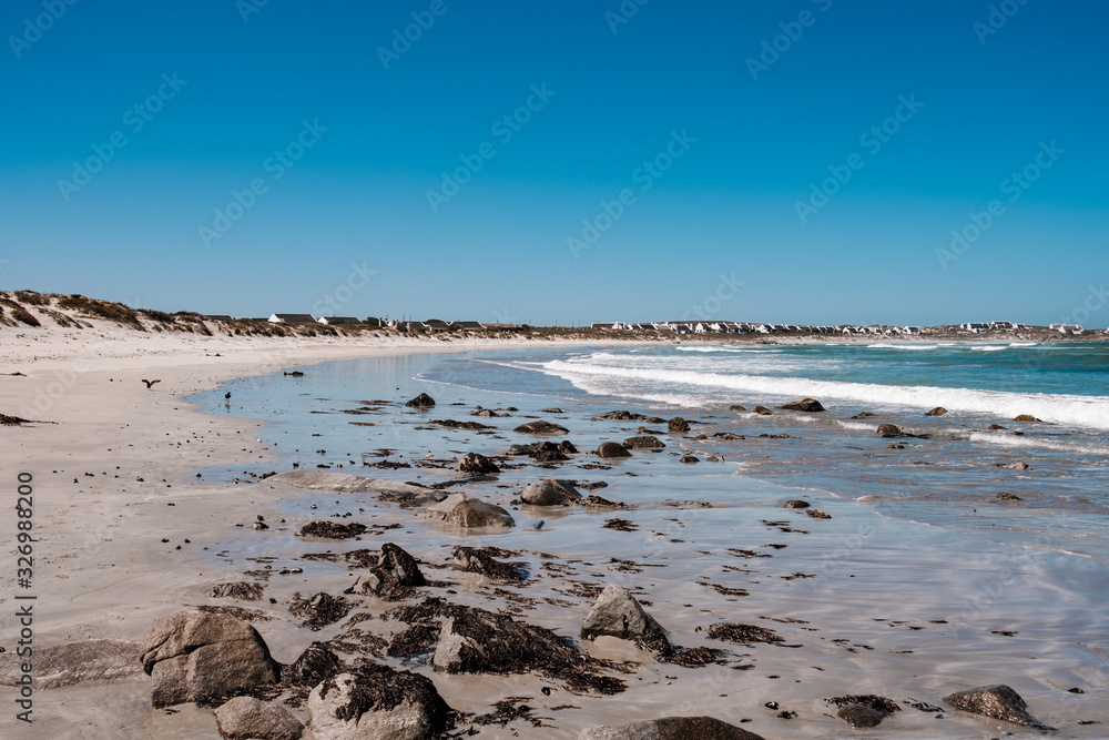 Natural long beach in Africa with waves and stones