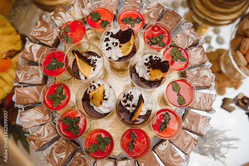 desserts with fruits, mousse, biscuits. Different types of sweet pastries, small colorful sweet cakes, macaron, and other desserts in the sweet buffet. candy bar for birthday