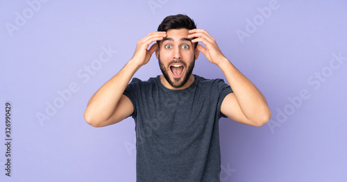 Caucasian handsome man with surprise expression over isolated purple background photo