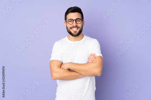 Caucasian handsome man over isolated background keeping the arms crossed in frontal position