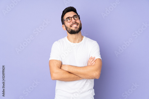 Caucasian handsome man over isolated background looking up while smiling