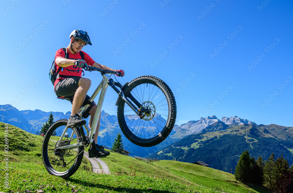 Wheelie auf dem Mountainbike in den Bergen des Montafons
