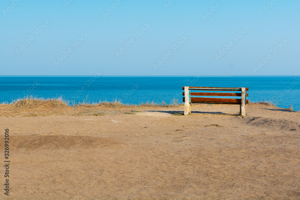 Empty bench on sea shore in steppe. Sea view from mountain. Travel, relax or loneliness concept