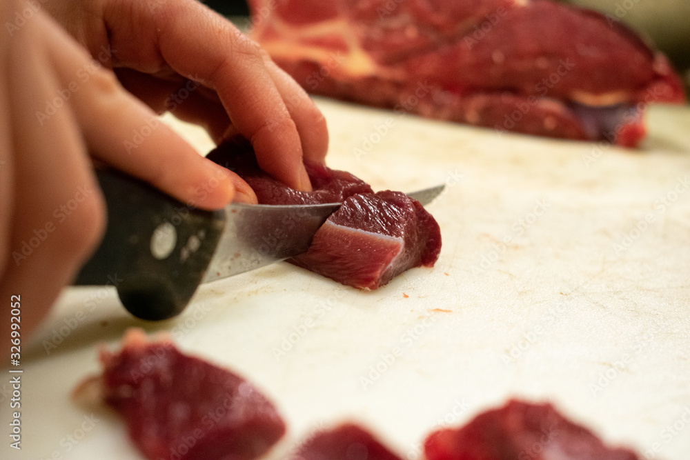 Cuting fresh meat on a cutting board Cuting fresh meat on a cutting board