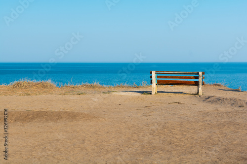 Empty bench on sea shore in steppe. Sea view from mountain. Travel  relax or loneliness concept