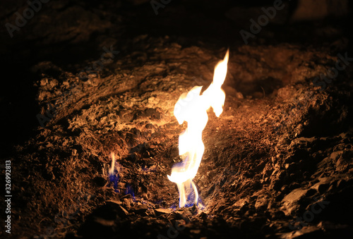 Natural gas comes out of the mounting stone and burning in night