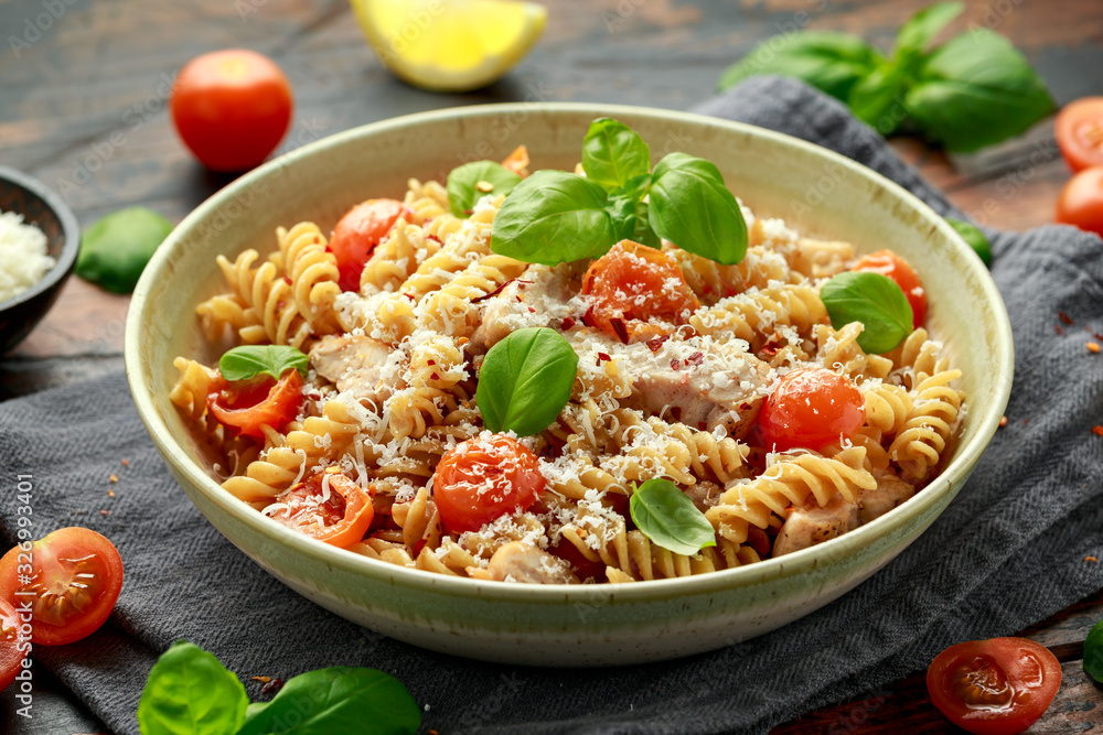 Healthy Chicken, fusilli pasta with tomatoes, basil and parmesan cheese. on wooden table. Healthy Chicken, fusilli pasta with tomatoes, basil and parmesan cheese. on wooden table.