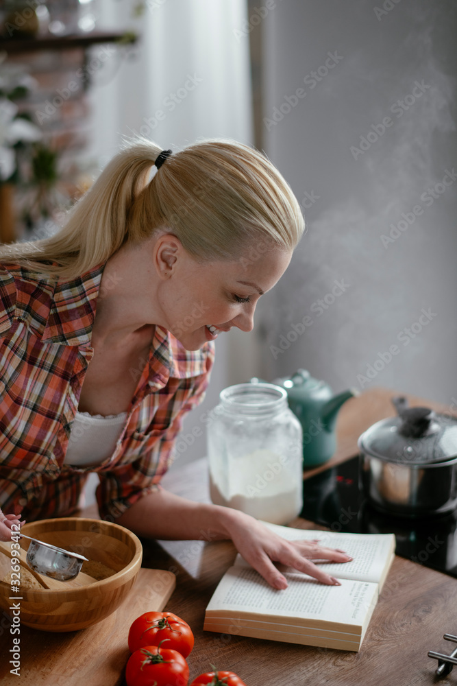 Woman in kitchen. Portrait of beautiful woman cooking. 