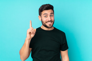 Caucasian handsome man isolated on blue background pointing with the index finger a great idea